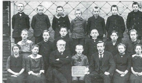 Konfirmanden mit den Lehrern Stoppenhagen und Rethmeier vor der Holler Schule 1919/1920