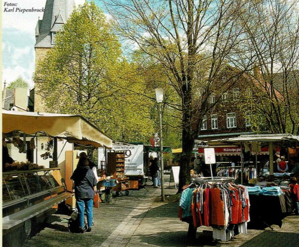 Blick auf den gut besuchten Isselhorster Wochenmarkt vor der Kirche