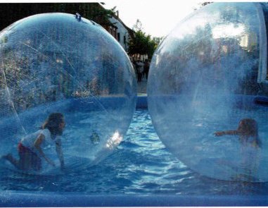 Die "Wasserstraße" mitten durch Isselhorst; Kinder gehen in Seifenblasen-Wasserbällen über das Wasser