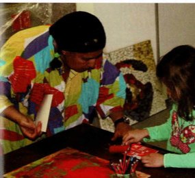 Museumspädagogin und Kinder betrachten konzentriert die Gemälde im Böckstiegel-Haus