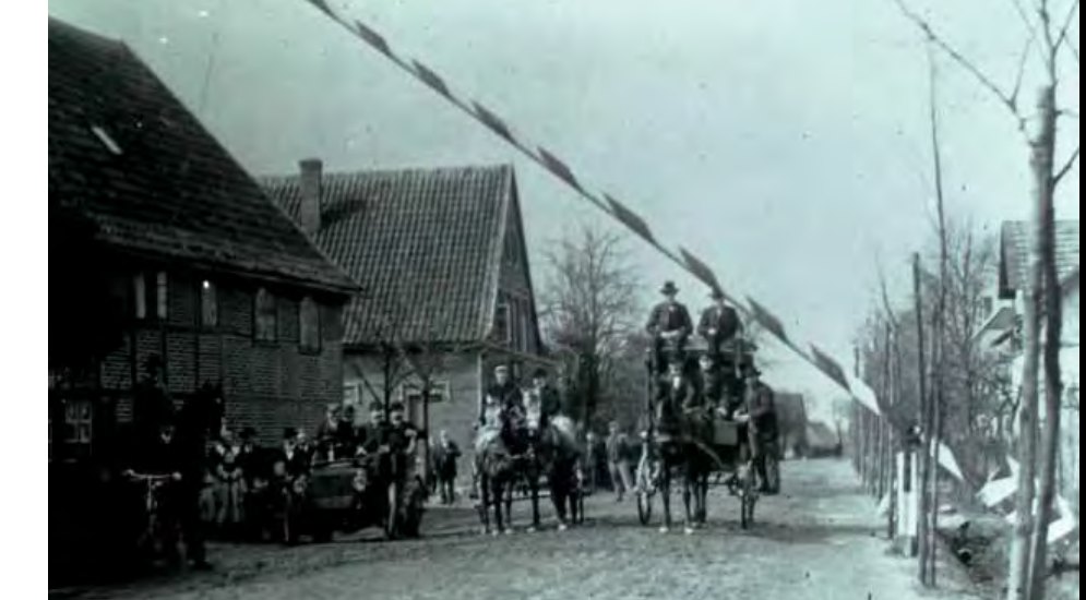 von 1904 mit der Postkutsche, dem frühen Auto und zahlreichen Dorfbewohnern am letzten Schlagbaum.