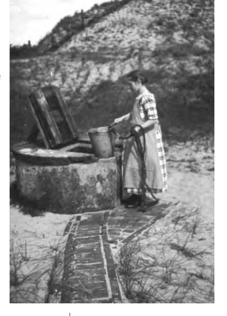 (um 1920) von Kornfelds Mutter beim Schöpfen von Trinkwasser auf Spiekeroog; Foto einer handgefertigten Schwen