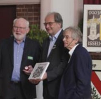 Henner Schröder und Siegfried Bethlehem überreichen Bürgermeister Matthias Trepper die neue Chronik 'Isselhors